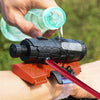 A hand is using a Spider Wrist Launcher water blaster to spray water onto a target.