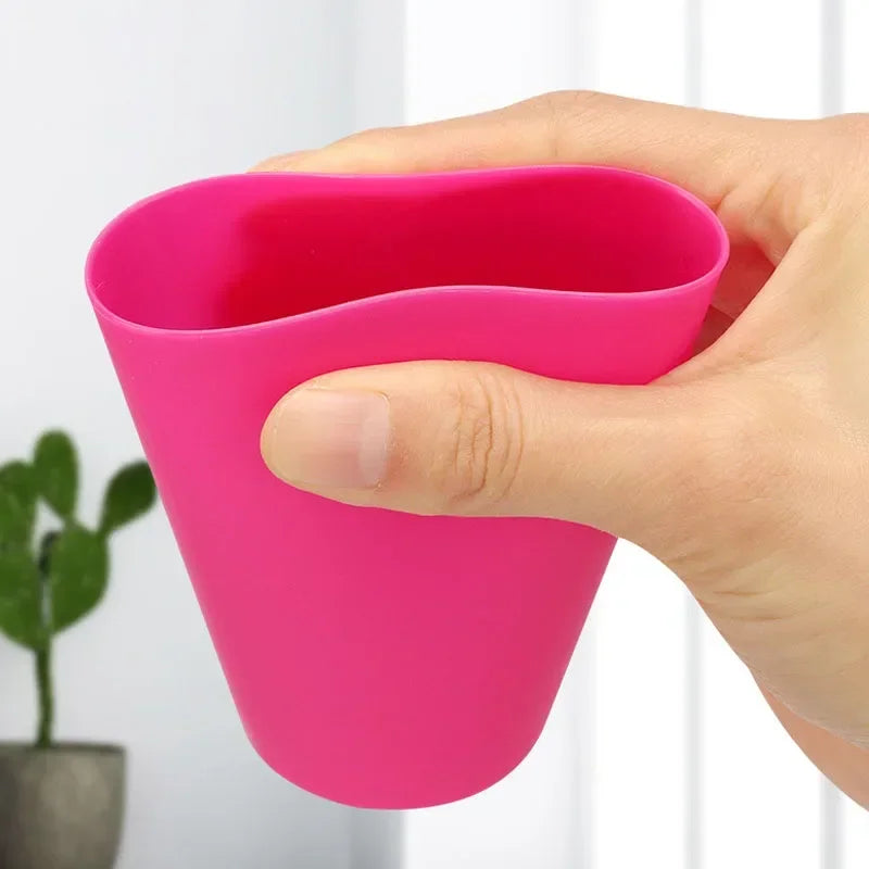 Eine Hand hält ein leuchtend pinkes Montessori Stapelspielset mit ergonomischem, gebogenem Design.