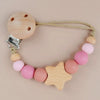 A wooden pacifier clip featuring silicone beads and a star shape for a baby.
