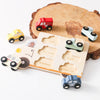 Wooden shape sorting puzzle featuring various colored toy vehicles like a fire truck ambulance and police car on a wooden boa