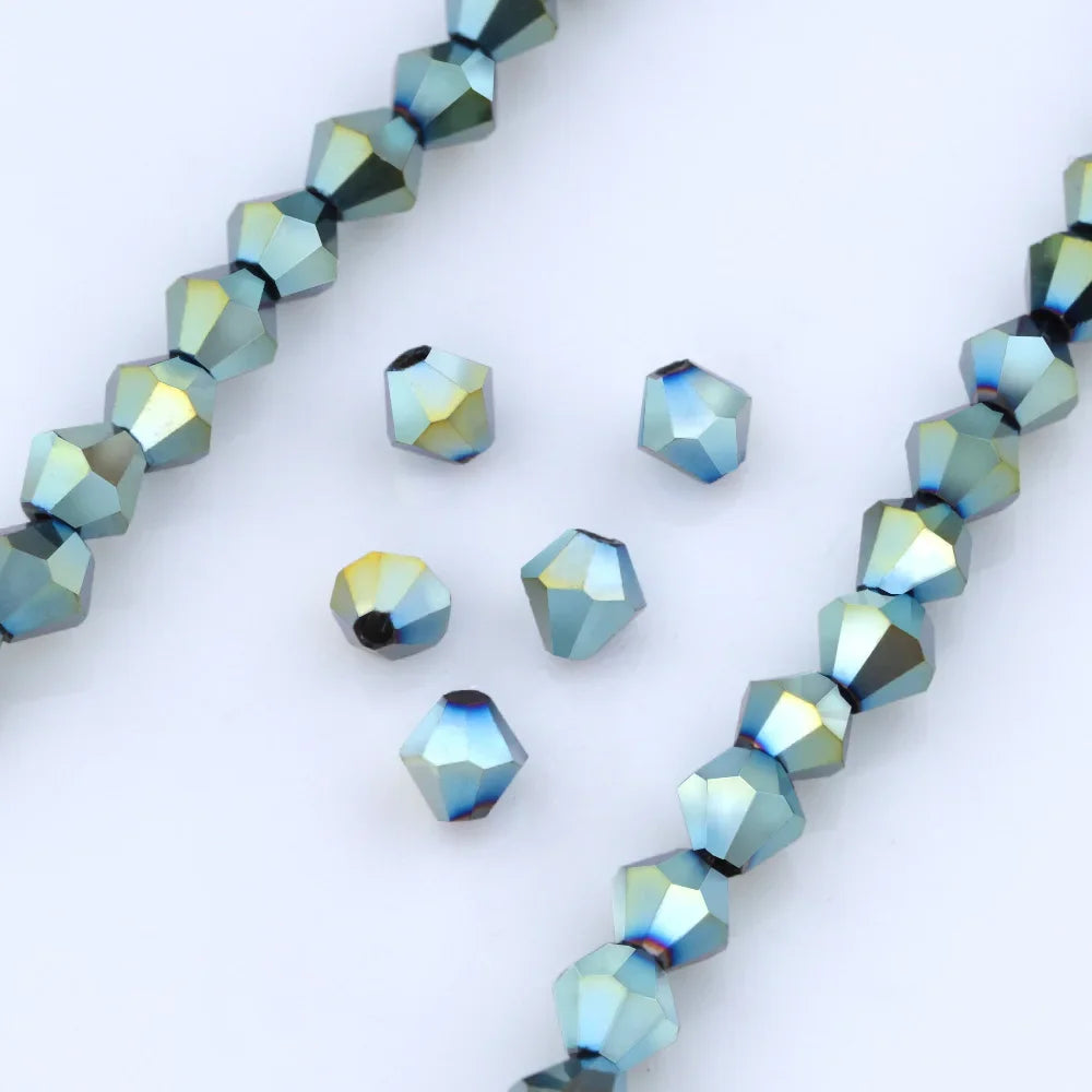 A close-up of blue and green faceted glass crystal beads arranged in a linear pattern.