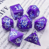 A set of purple resin dice featuring black kitten designs and numbered faces.