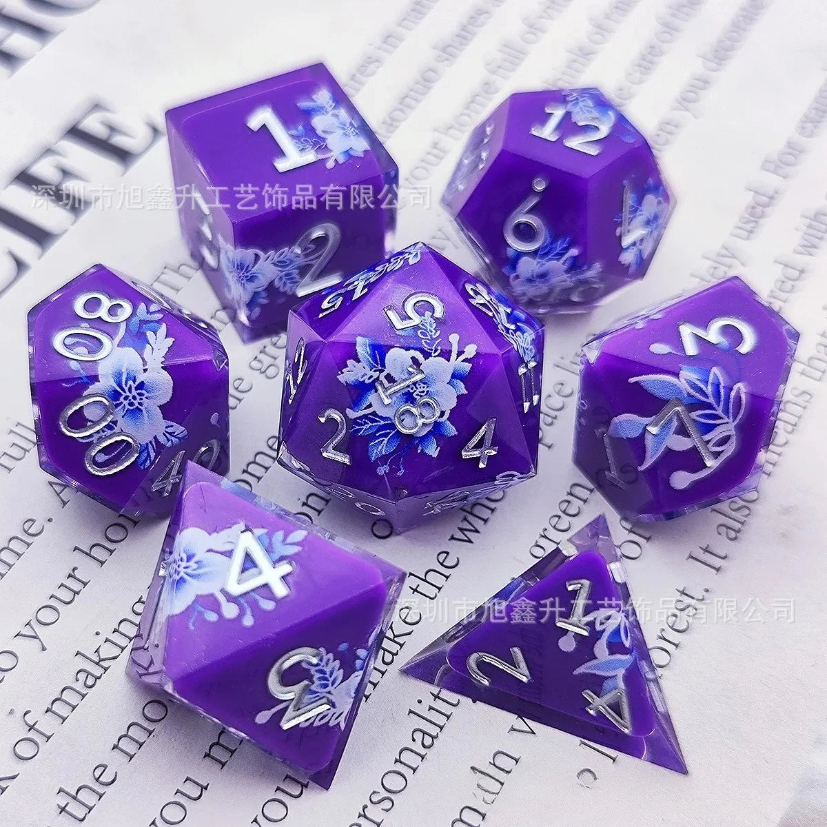 A set of purple resin dice featuring black kitten designs and numbered faces.