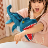 Une jeune fille tient un jouet de marionnette en peluche d'un dinosaure bleu.
