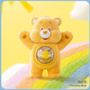 A yellow Funshine Bear collectible figurine standing against a colorful rainbow background.