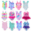 A collection of colorful kids mermaid and unicorn one-piece swimsuits in various patterns and colors.