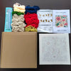 A box containing a flower pattern punch needle embroidery kit with various colored threads and instructions.