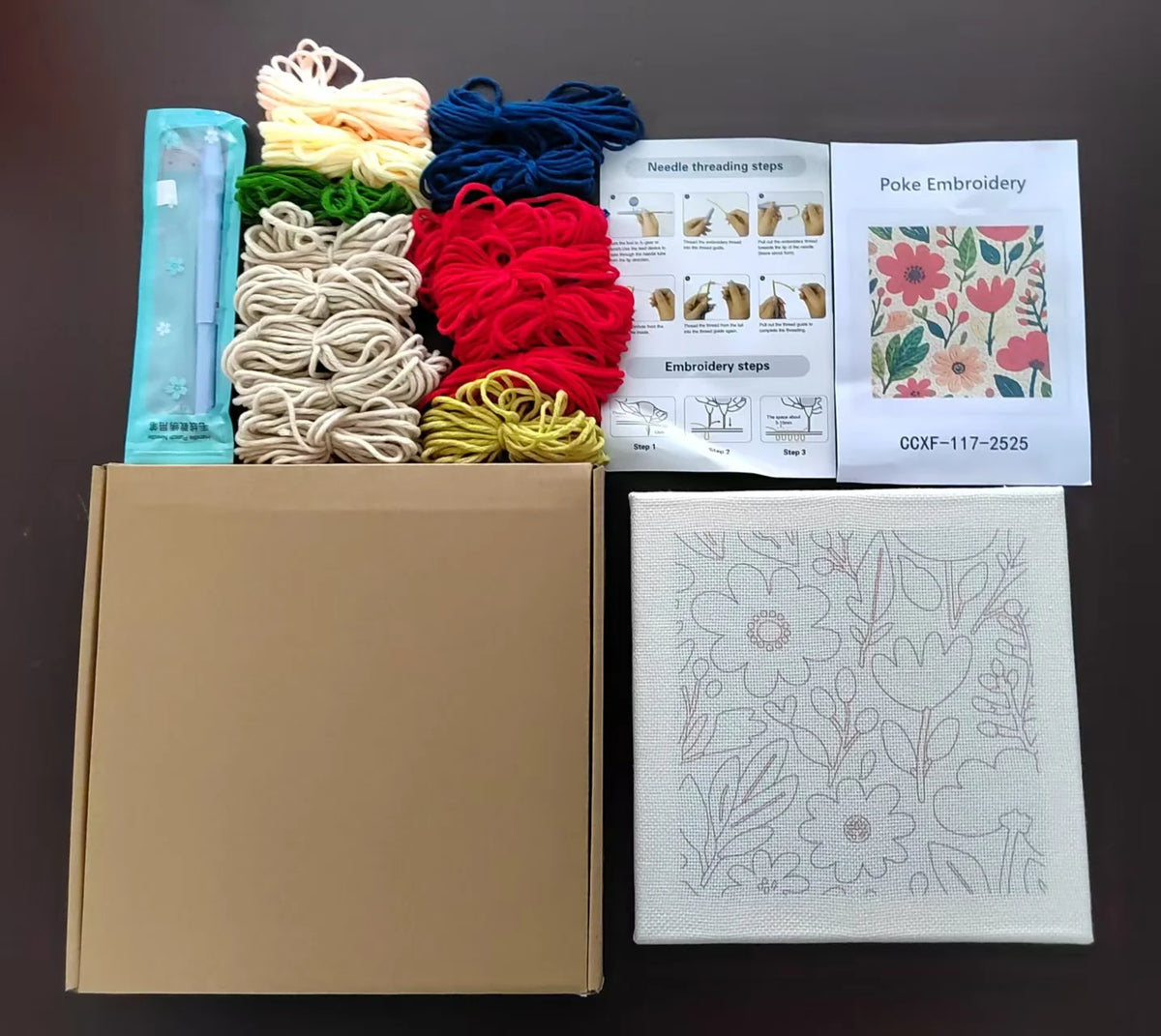 A box containing a flower pattern punch needle embroidery kit with various colored threads and instructions.