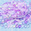 A pile of iridescent purple and pink water drop Czech glass beads for jewelry making