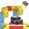 A magnetic train engine made of colorful plastic pieces with a black vehicle attached and a yellow track section.