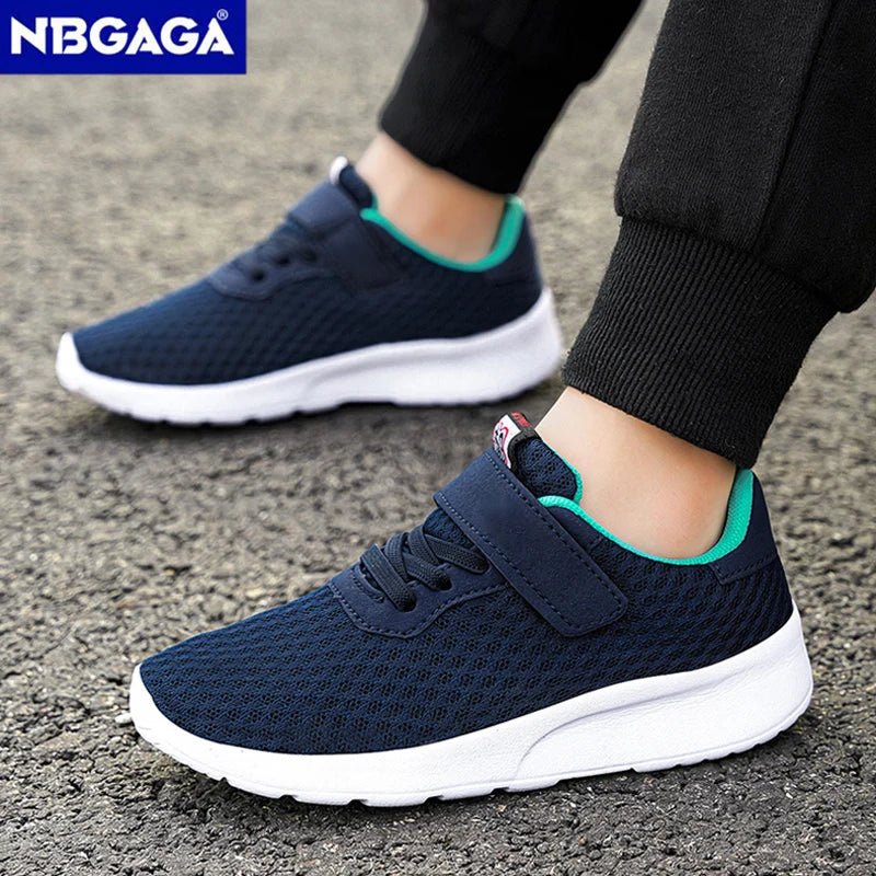 A pair of navy blue breathable mesh kids' sneakers with white soles and hook-and-loop closures worn on a person's foot.
