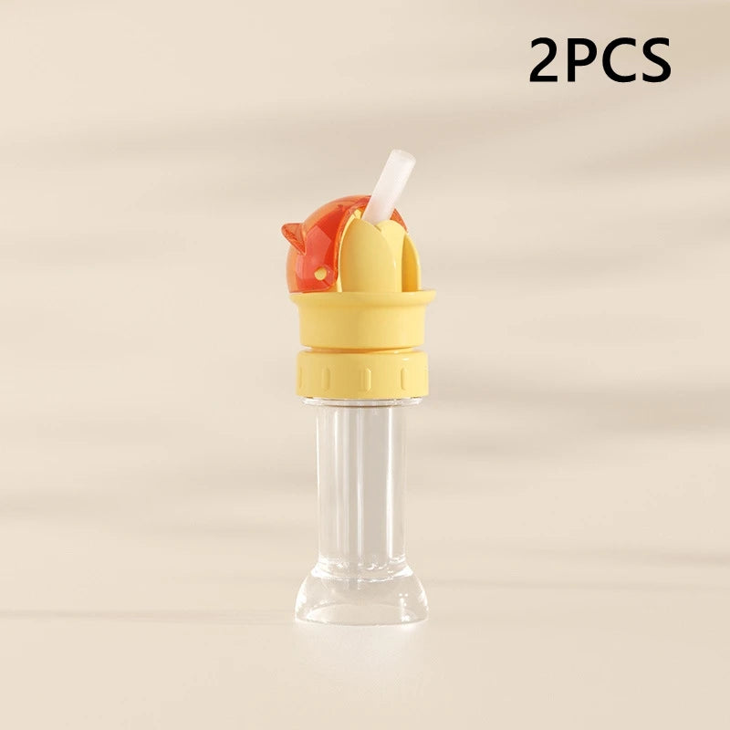 Two pieces of a yellow and orange anti-choking straw and bottle cap converter for kids