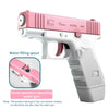 A pink and white hand-operated repeating water gun is shown, with an inset detail of the water filling spout.
