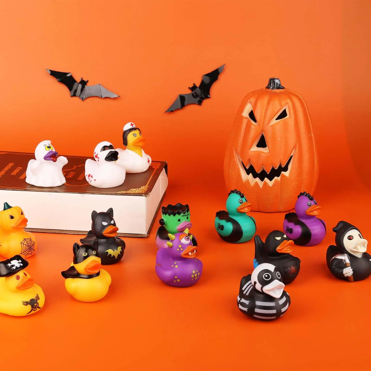 A collection of twelve festive Halloween-themed rubber duck characters and a carved pumpkin against an orange background.