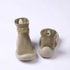 A pair of soft-soled baby first walker socks shoes in a muted olive green color.
