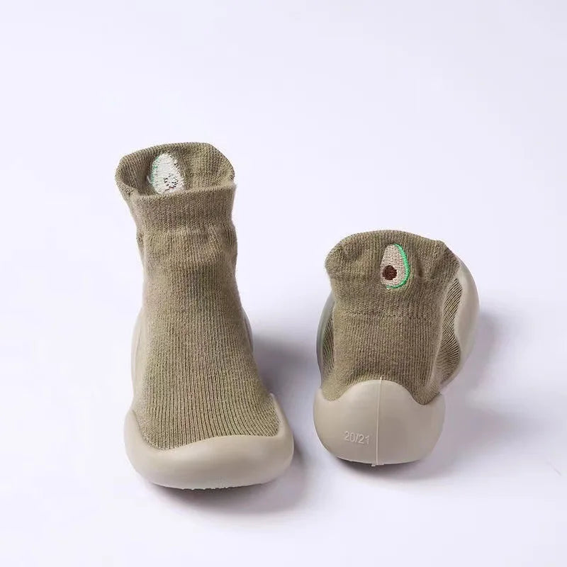 A pair of soft-soled baby first walker socks shoes in a muted olive green color.