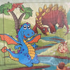 A jigsaw puzzle featuring a blue dinosaur and a reddish-brown dinosaur on a green landscape.