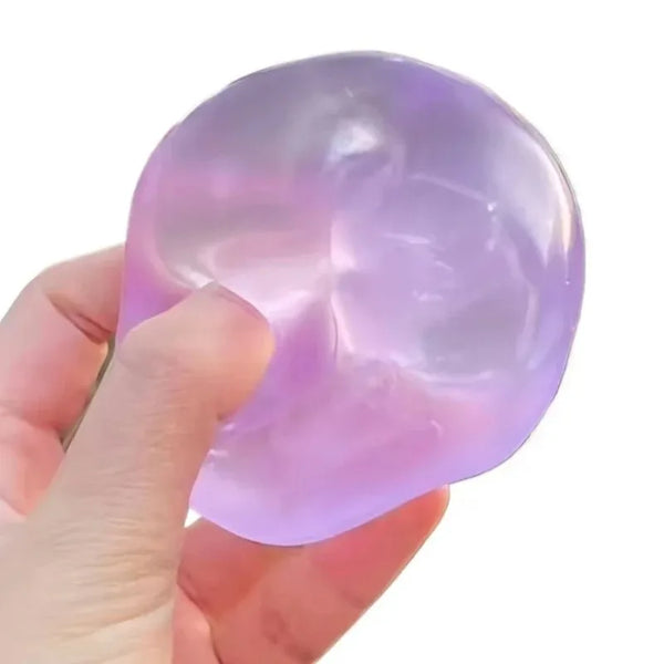 A hand is squeezing a translucent purple mochi-like fidget toy for stress relief.