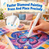 A hand uses a white diamond painting pen to place beads onto a fabric featuring a colorful butterfly design.