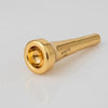 Gold-plated trumpet mouthpiece with a cylindrical body and a flared opening.