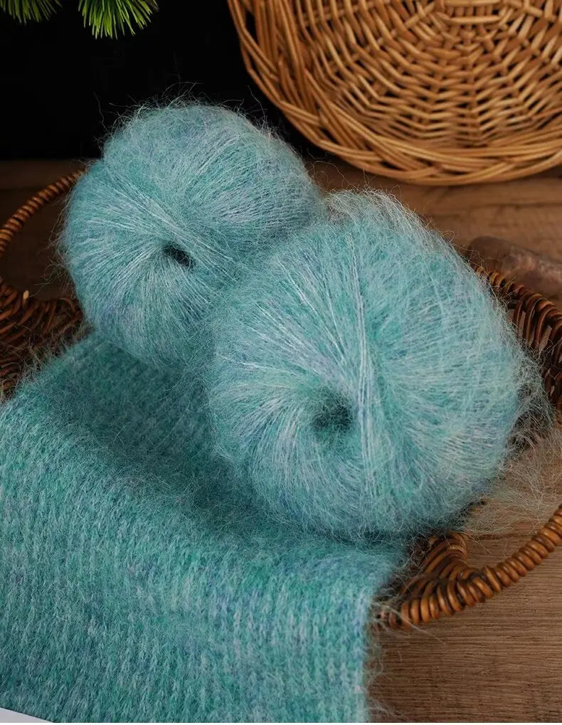 A close-up of two fluffy, light blue alpaca blend yarn balls resting on a woven basket.