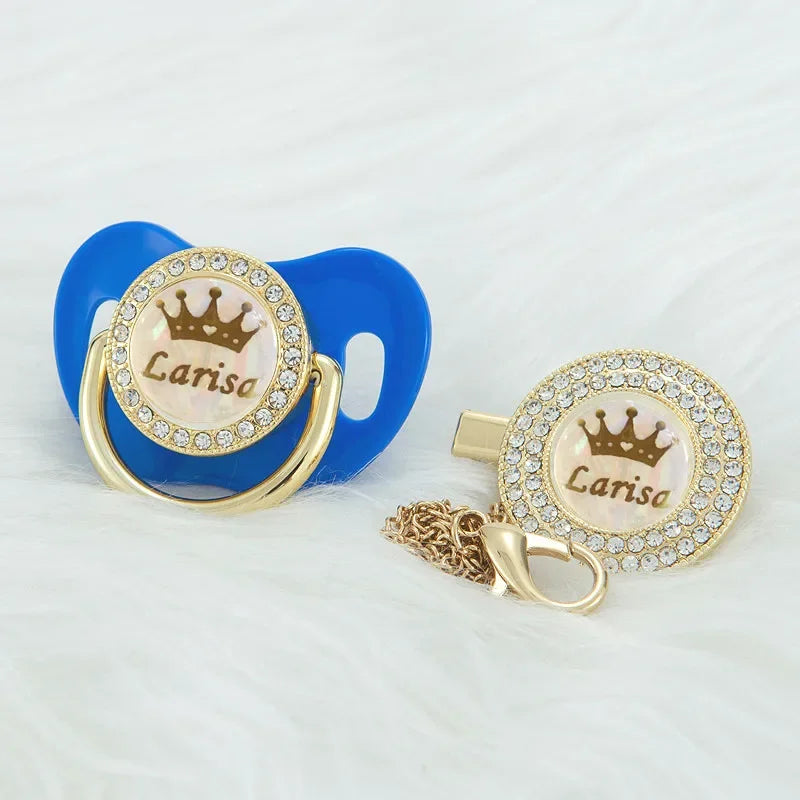 Personalized rose gold crown pacifier and clip set with a blue silicone holder