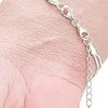 A close-up of a delicate silver chain necklace with magnetic clasps draped on a person's wrist.