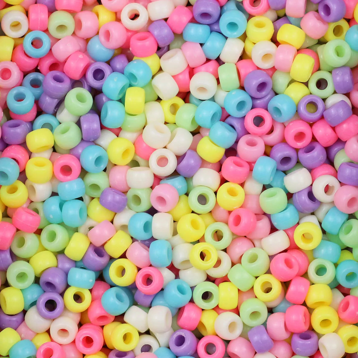 A close-up view of a large pile of multicolor pony beads in various shades of pink, yellow, green, and purple.