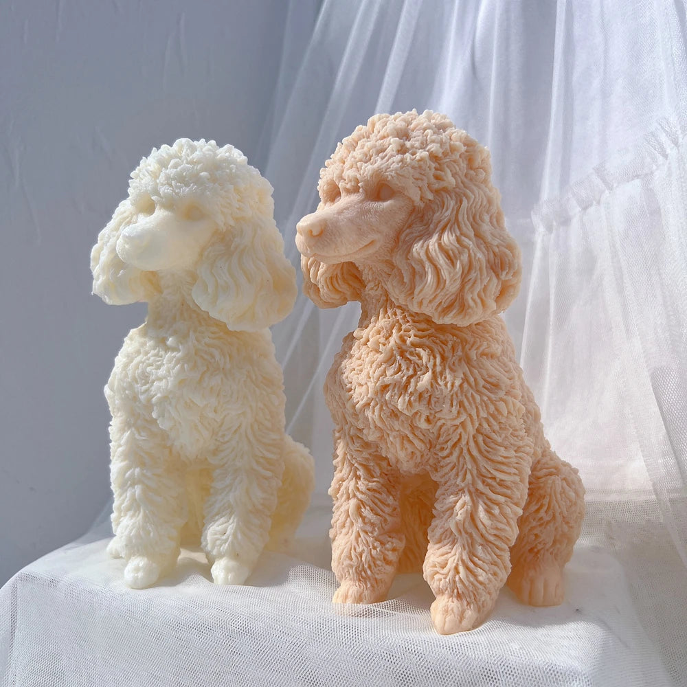 A pair of fluffy poodle dog silicone candle molds in white and peach colors sitting on a white fabric.
