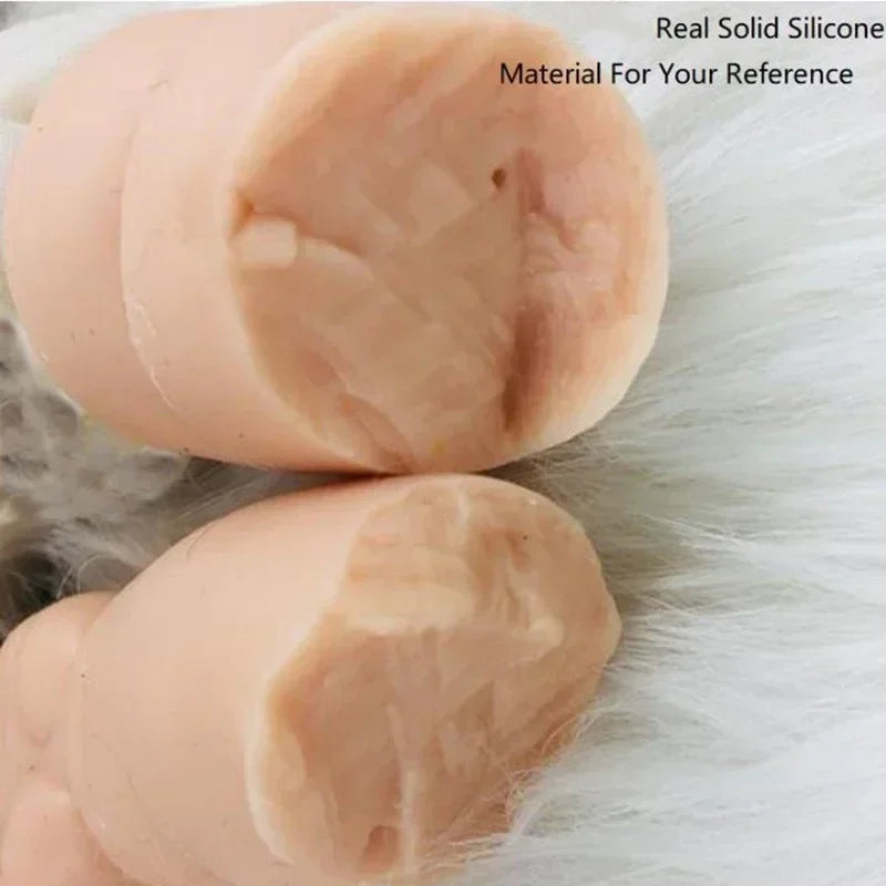 A close-up view of a small, soft silicone reborn piglet doll in a pale pink color resting on white fur.