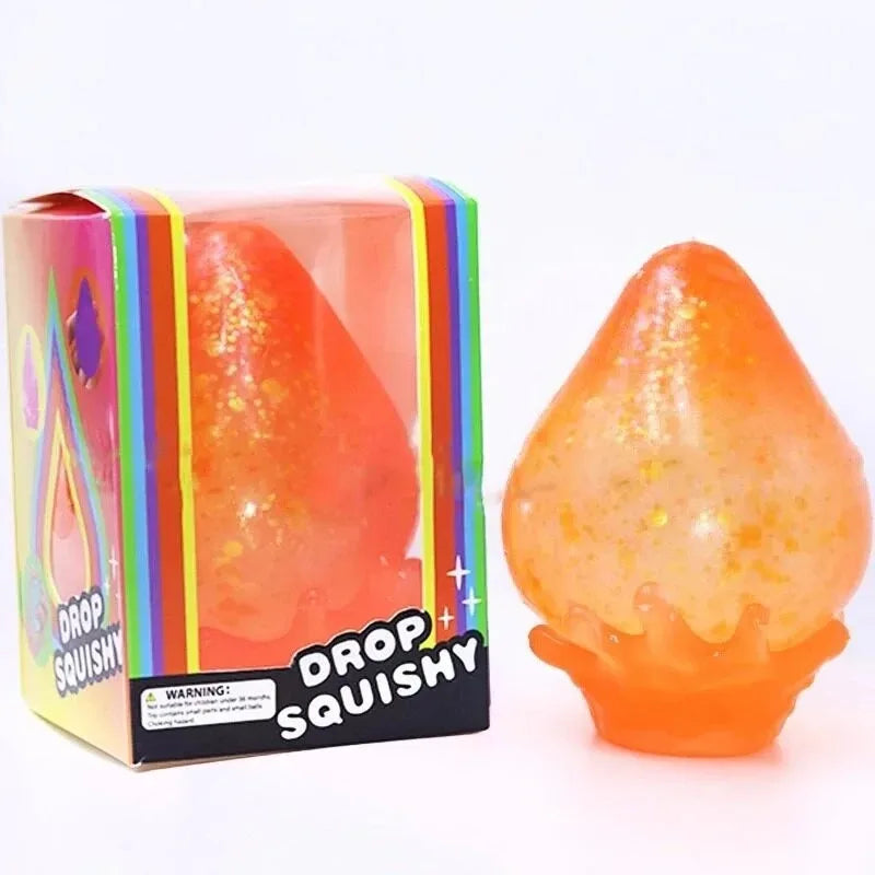 A squishy toy shaped like a raindrop in orange and yellow colors, packaged in a box.