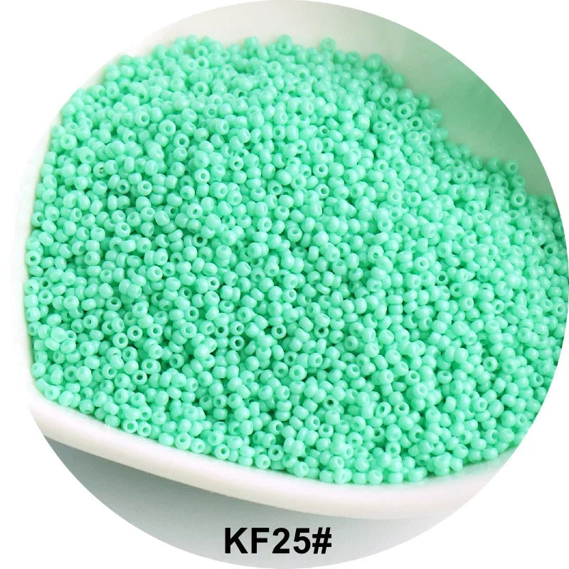 A pile of bright green 1.5mm solid glass seed beads in a white bowl.