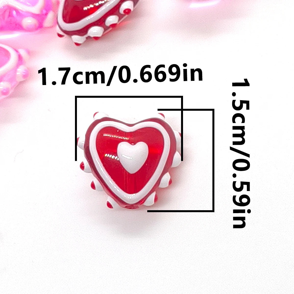 A close-up of a red heart-shaped lampwork glass bead for jewelry making, measuring 1.7cm long.