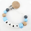 A personalized pacifier clip featuring silicone teething beads in natural wood and blue colors.