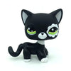 A black and white Littlest Pet Shop style standing dog figure with large green eyes.