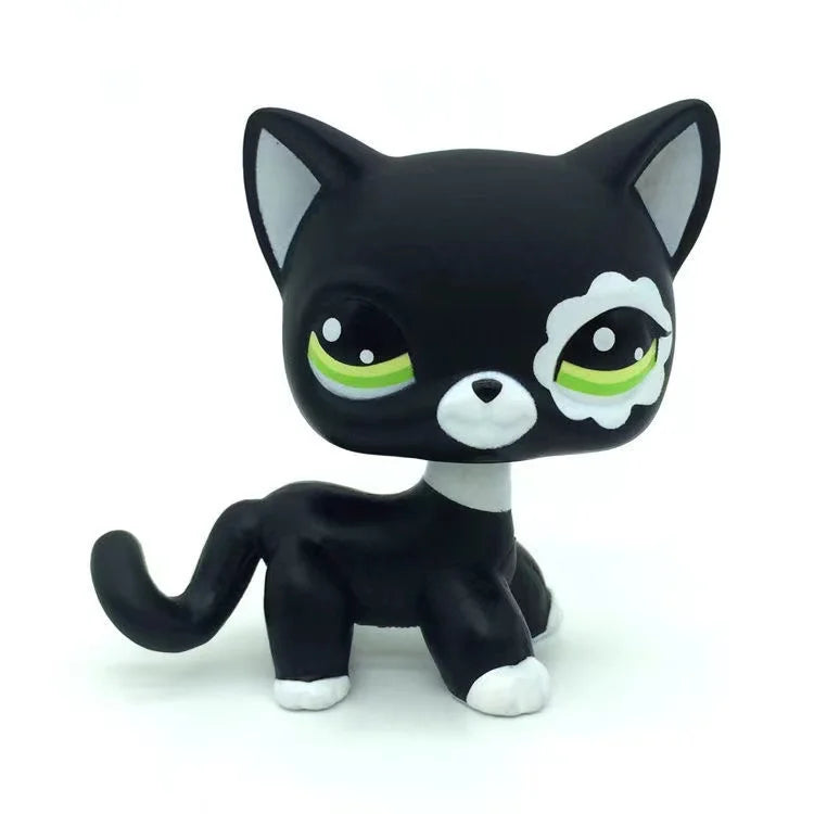 A black and white Littlest Pet Shop style standing dog figure with large green eyes.
