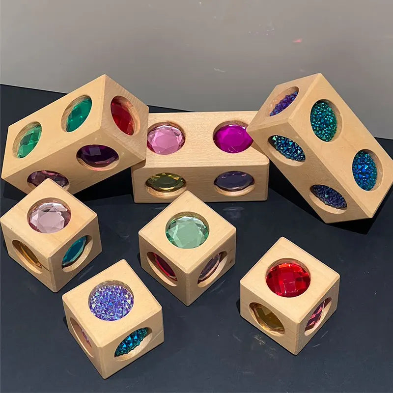 A collection of wooden building blocks with colorful acrylic gems and stones.