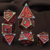 A set of seven polyhedral metal dice, including a d10 and d6, displayed against a dark background.