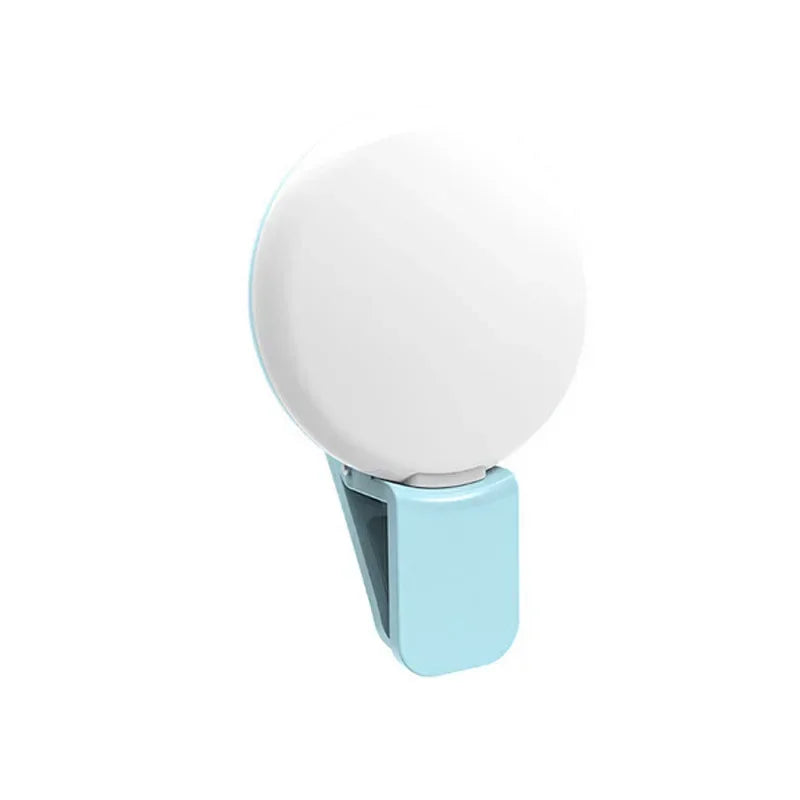 A portable LED selfie ring light with a white circular light and a light blue clip.