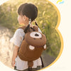 Une jeune fille porte un sac à dos anti-perte marron pour enfant avec un motif d'éléphant et une sangle de sécurité.