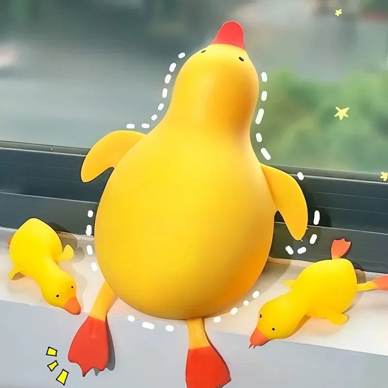 A large yellow duck squishy toy with orange feet is shown in a close-up against a light background.