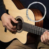 A hand plays a light-colored acoustic guitar with silver-plated nylon strings.