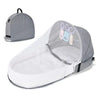 A portable foldable baby bed with a mosquito net and mattress shown in gray.