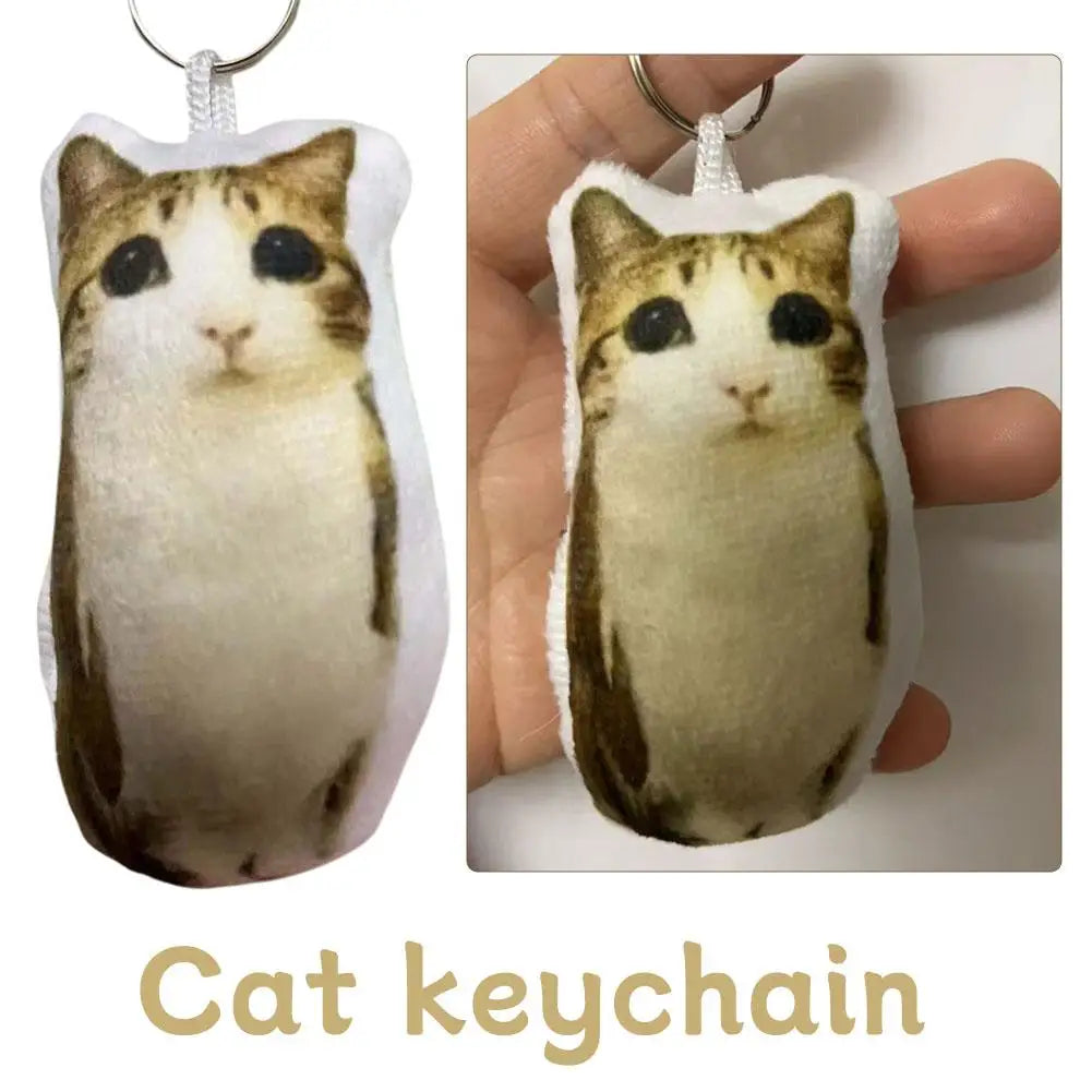 A soft, light brown and black cat plush keychain with a white tag.