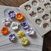 A collection of colorful silicone molds shaped like flowers and roses for chocolate and cake decorating.
