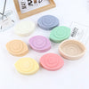 A collection of round silicone molds in various pastel colors for candles, soap, and resin art.