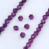 A collection of purple and violet faceted glass beads arranged in linear strands and scattered pieces for jewelry making