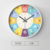 A round analog clock face with colored numbers and hands, featuring a grid of colors for teaching purposes.