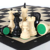 A portable folding chess set with weighted black and white pieces displayed on a checkered board.