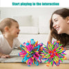 A smiling woman interacts with a baby while playing with a colorful expandable magic ball toy.